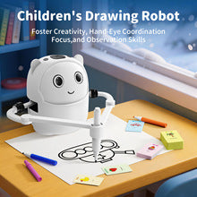 White 3-in-1 music and art learning station toy with a robot arm and pen, shown on a wooden table with drawing cards, music notes, and product feature icons.